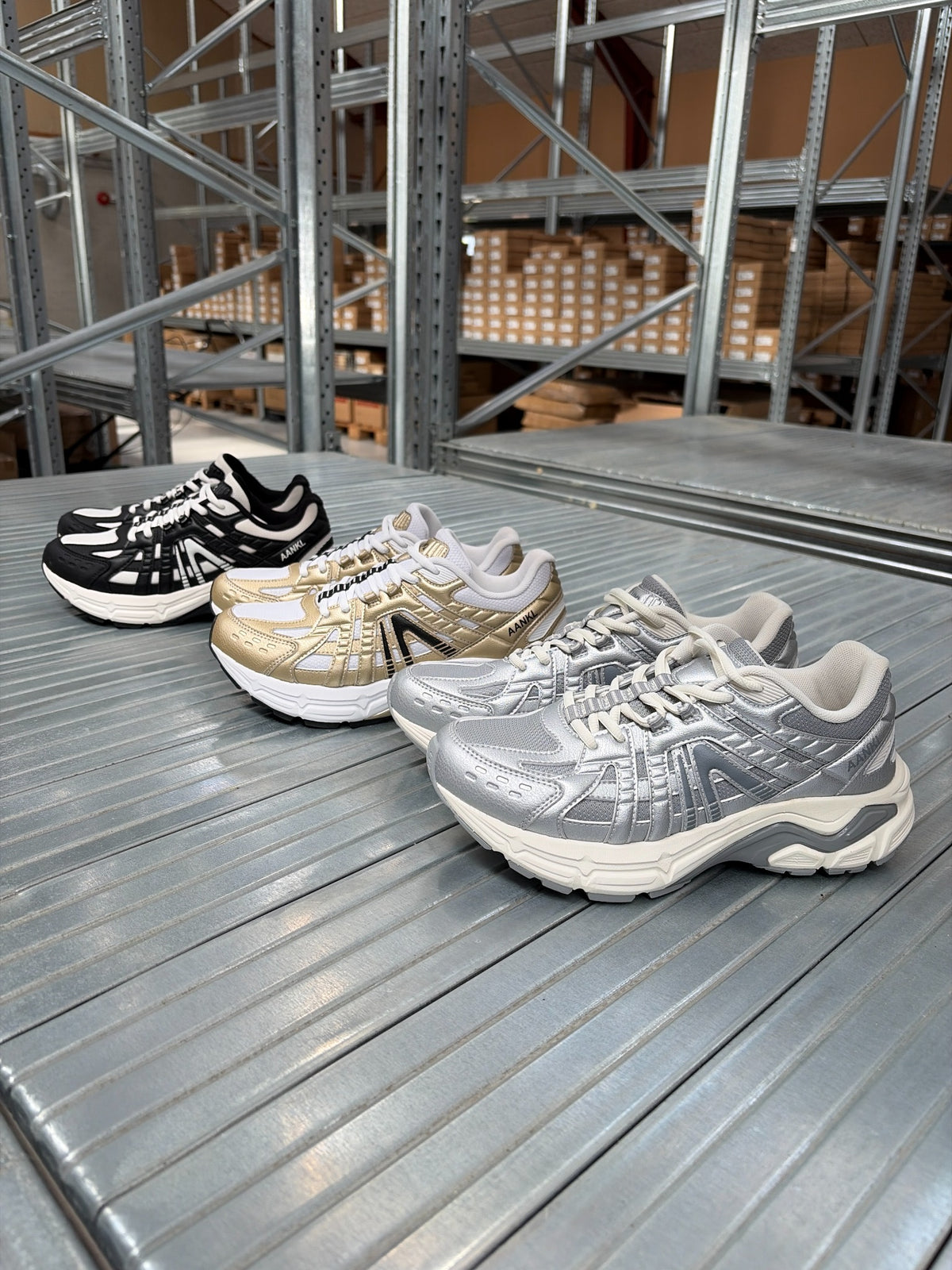 AANKL GLIDE Black/White, Gold/White og Silver – originalfoto af tre par på lagerets metalbane